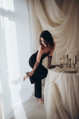 Mumların ve kumaşların yanına çıplak ayakla adım atan zarif bir kadın.