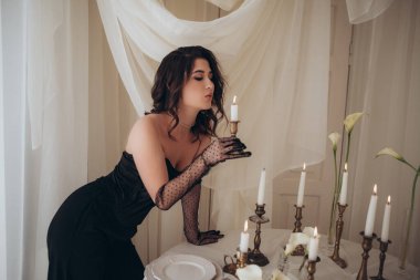 Mum ışığını nazikçe üfleyen kadının romantik portresi