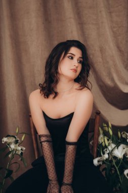 Siyahlı, çiçekli, şık bir kadının yakın çekimi.