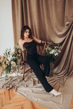 Hareketli kadın zambakların arasında sandalyeden uzaklaşıyor