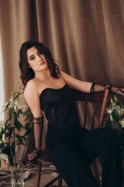 Yumuşak bir ifade ve çiçek dekoru olan bir kadın.