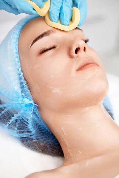 beautician cleanses skin of beautiful woman with sponge. close-up. Perfect cleaning, spa treatment skincare face.