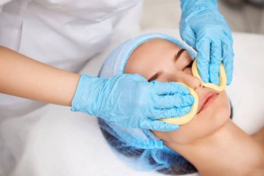 Güzellik uzmanı cildini süngerle temizliyor. Mükemmel temizlik, spa tedavisi cilt bakımı.