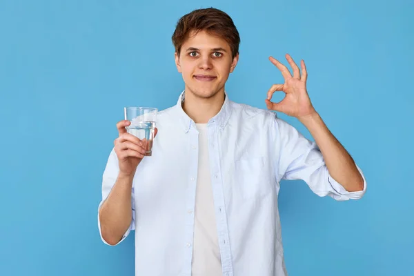 Giovane Bell Uomo Con Bicchiere Acqua Potabile Gesto Sfondo Blu — Foto Stock