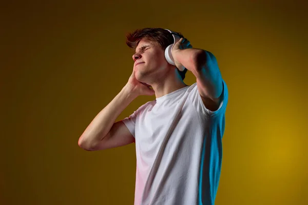 Kulaklıklı Genç Adam Sarı Arka Planda Sevdiği Müziğin Keyfini Çıkarıyor — Stok fotoğraf