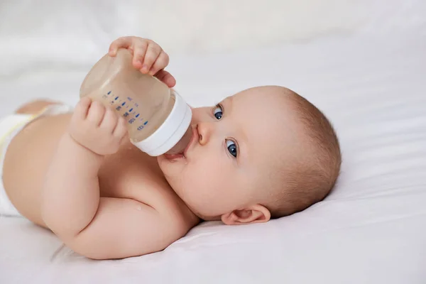 Charming Baby Girl Lies Bed Drinks Water Bottle — Stock Photo, Image