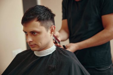 Berber berber dükkanında yakışıklı beyaz adamı tıraş ediyor..