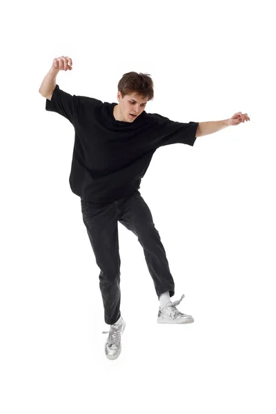 stock image young man in black t-shirt jumping isolated on white background