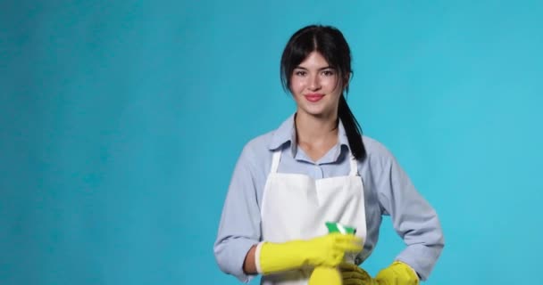 Hübsche Frau Gummihandschuhen Und Putzschürze Die Waschmittelsprüher Auf Blauem Hintergrund — Stockvideo