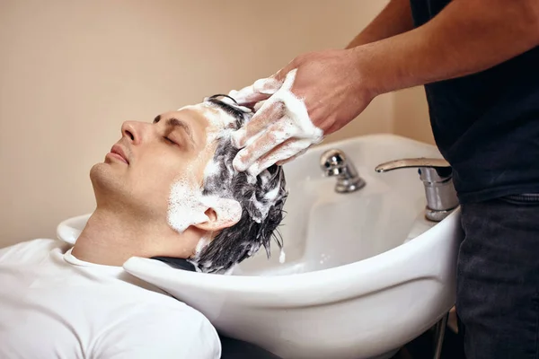 理发店里的白人理发师洗头 — 图库照片