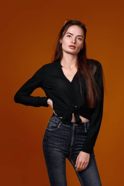 Renkli stüdyo arka planda siyah gömlekli kadın ve kot pantolon.