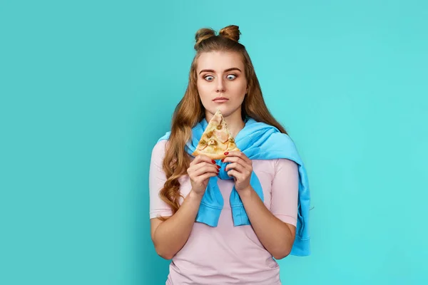 Голодна Жінка Дивиться Шматочок Піци Синьому Фоні — стокове фото