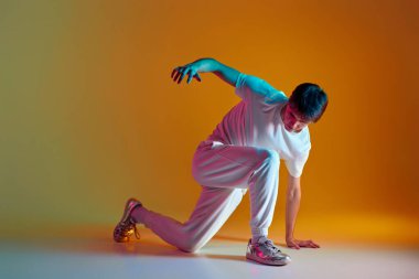 Sarı arka planda dans eden yakışıklı adam. Neon ışıkları