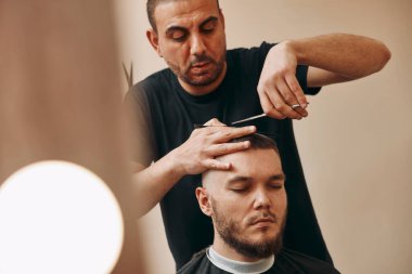 Usta kuaför yakışıklı, mutlu, sakallı, beyaz adamı kesiyor..