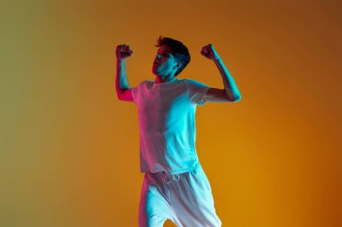 Sarı arka planda dans eden yakışıklı adam. Neon ışıkları