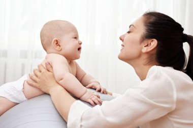 Küçük kızıyla evde spor salonunda jimnastik yapmaktan mutlu.