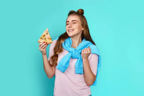 beautiful young woman with pizza slice on blue background.