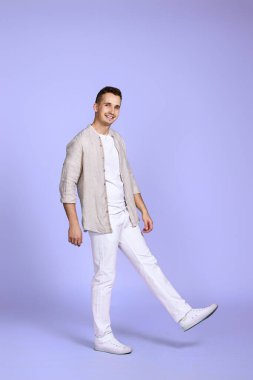 Yakışıklı, mutlu adam menekşe arka planda tek başına yürüyor..