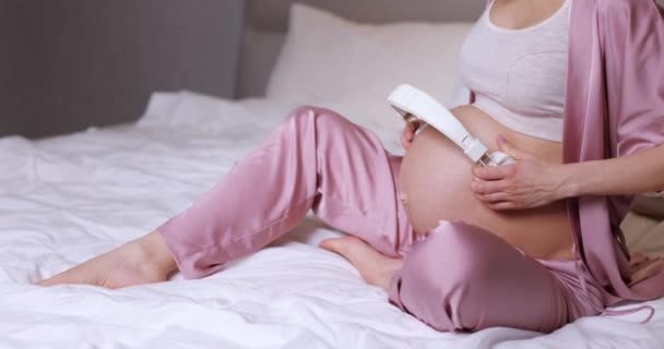 Beautiful Pregnant Woman Holding Headphones Her Belly Bedroom — Stock video