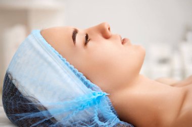 Kaplıca salonundaki genç ve güzel kadın. Sağlıklı yumuşak tenli bir kadın yüzü