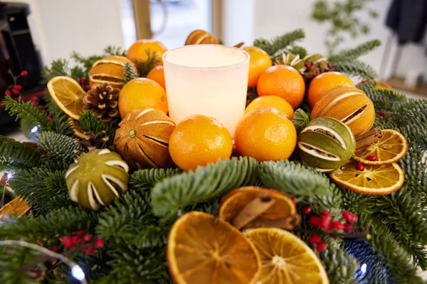 Christmas tree wreath with white candles, dry orange, cone. eco-friendly home decoration
