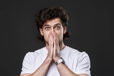 Portrait of frustrated young man on dark gray background. sadness