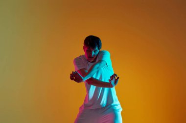 Sarı arka planda dans eden yakışıklı adam. Neon ışıkları