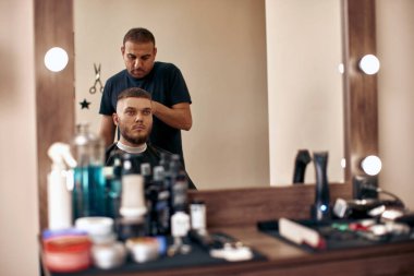 Berber berber dükkanında sakallı yakışıklı adamı tıraş ediyor..