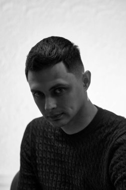 young man with stylish hair and beard looking at camera on white background