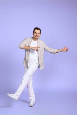 Yakışıklı, mutlu adam menekşe arka planda tek başına yürüyor..