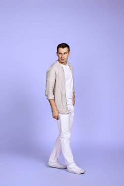 handsome man walks isolated on violet background.
