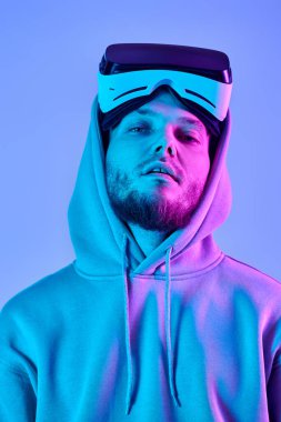 handsome man in virtual reality headset on blue background. Neon lighting