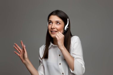 Kulaklıklı mutlu kadın internetten müşterilere danışıyor. Çağrı merkezi