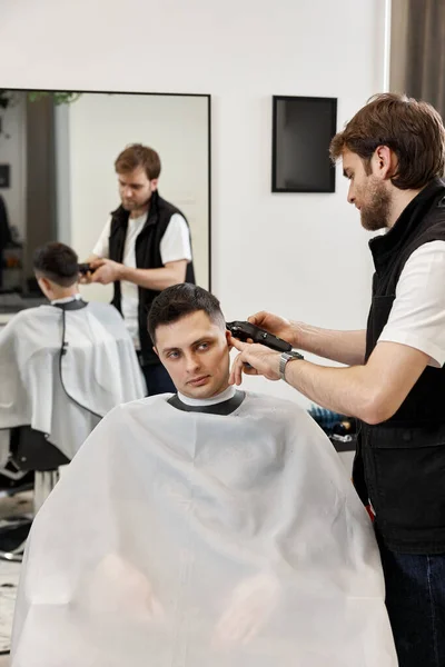 理发店理发师剃光英俊的高加索男人 — 图库照片