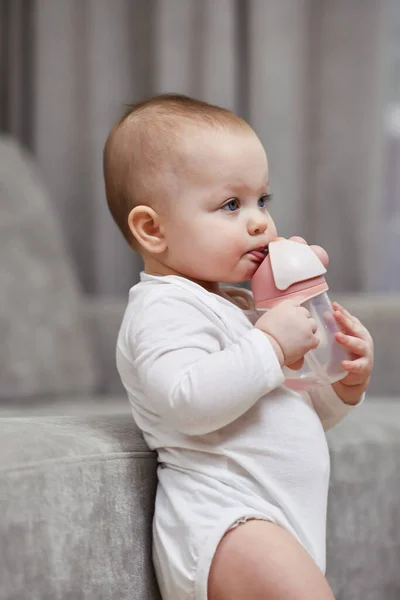 Cute Baby Girl Holding Bottle Drinking Water Home — Stock Photo, Image