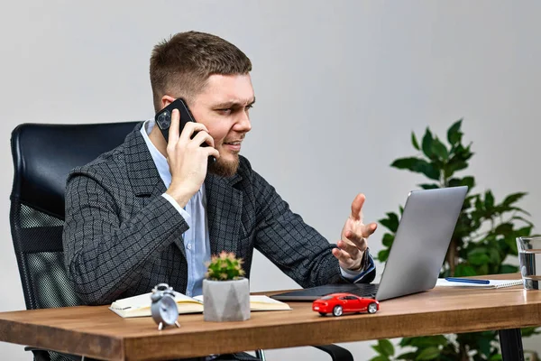 사업가가 노트북을 가지고 일하고 전화로 얘기하는 — 스톡 사진