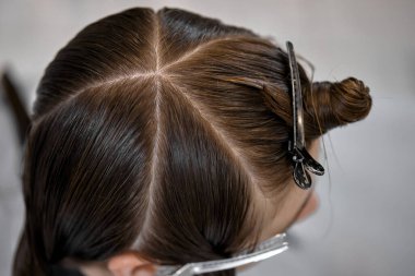 young girl gets fashionable haircut in modern hairdressing salon
