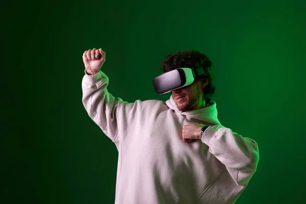 Man Sweatshirt Using Virtual Reality Headset Green Background Neon Lighting — Stock fotografie
