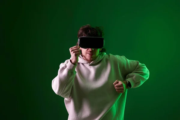 Человек Свитере Гарнитурой Виртуальной Реальности Играющий Видеоигры Зеленом Фоне Неоновое — стоковое фото
