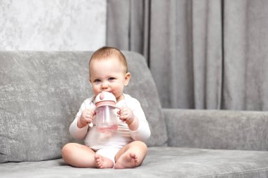 Şişe tutan ve evde su içen tatlı bir kız..