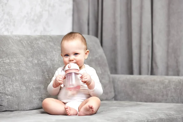 Cute Baby Girl Holding Bottle Drinking Water Home — Stock Photo, Image