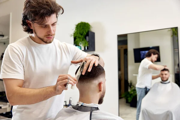 Hairdresser Does Haircut Caucasian Bearded Man Using Comb Grooming Scissors — Zdjęcie stockowe