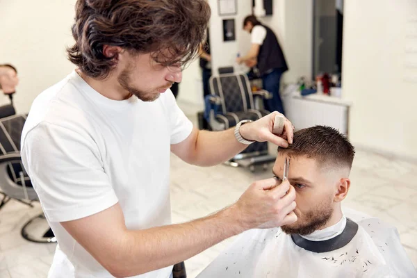 Hairdresser Does Haircut Caucasian Bearded Man Using Comb Grooming Scissors — Zdjęcie stockowe