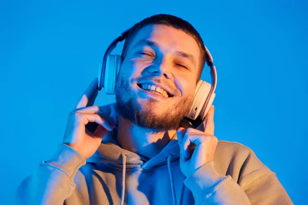 Handsome Bearded Man Headphones Sweatshirt Enjoying Favorite Music Blue Neon — Stok fotoğraf