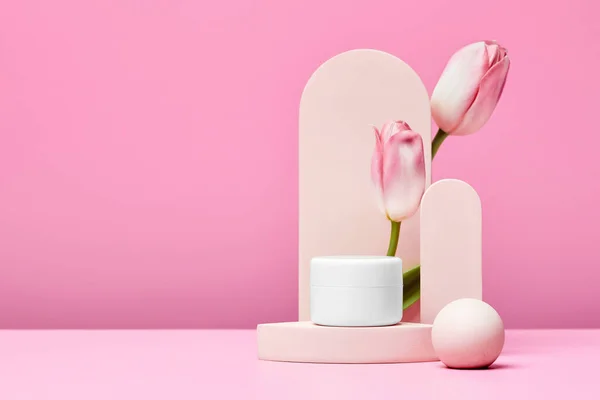 Biały Słoik Kosmetycznego Produktu Premium Podium Różowymi Tulipanami Eleganckim Łukiem — Zdjęcie stockowe