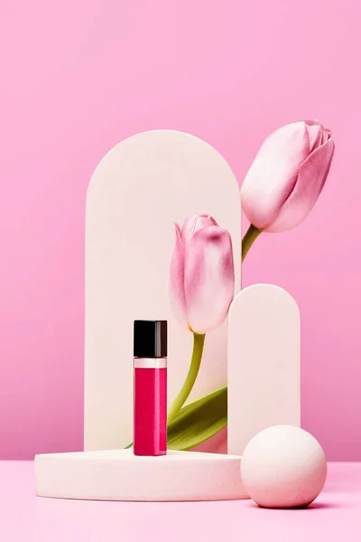 Lipgloss Auf Dem Podium Mit Rosa Tulpen Und Elegantem Bogen — Stockfoto