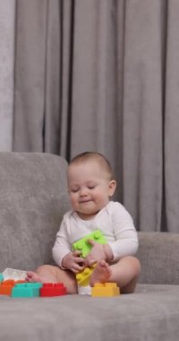 Evde renkli oyuncak bloklarıyla oynayan tatlı bir kız bebek. Çocuklar için erken gelişme.