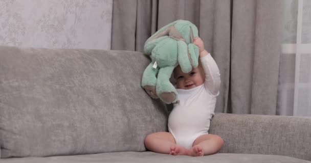 可爱的小女孩在家里玩松软的玩具兔子 — 图库视频影像