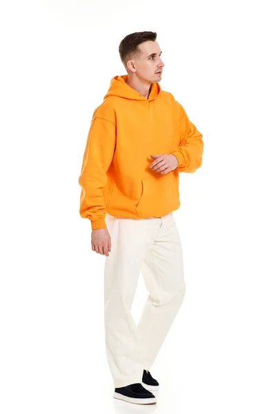 白い背景にあなたのロゴやデザインのためのスペースとオレンジの空白のスウェットシャツの若いハンサムな男 完全長のためのモックアップ Print — ストック写真