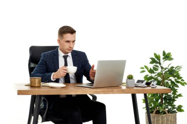 young friendly man talking at laptop webcam, sitting on chair at desk, using laptop pc computer